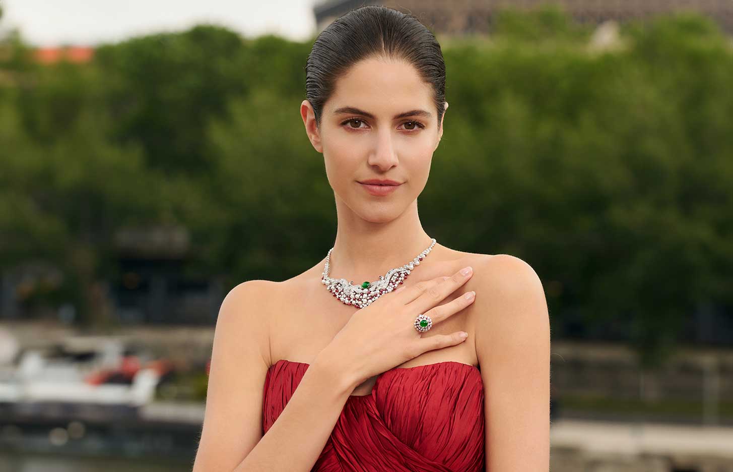 A model wears the HEHE High Jewelry Dragon Harmony Dual Dragon Fetching Water necklace and ring from the  Ascending Dragon High Jewellery collection with red spinel beads, green jadeite cabochons, pearls, and diamonds 