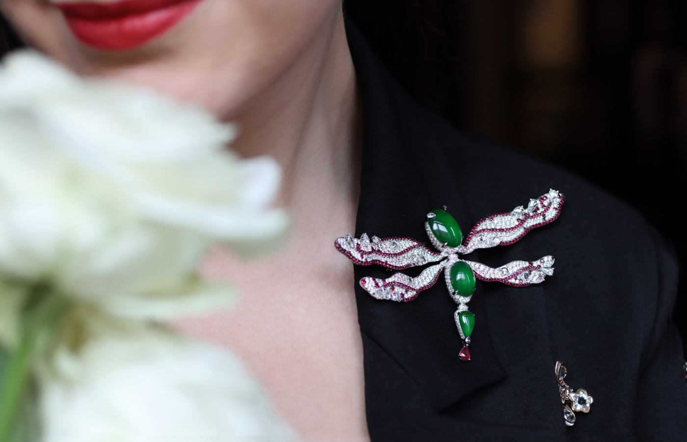 Katerina Perez wears the HEHE High Jewelry Dragonfly’s Realm brooch with three green jadeite cabochons, rubies and diamonds from the West Lake Jadeite High Jewellery collection 