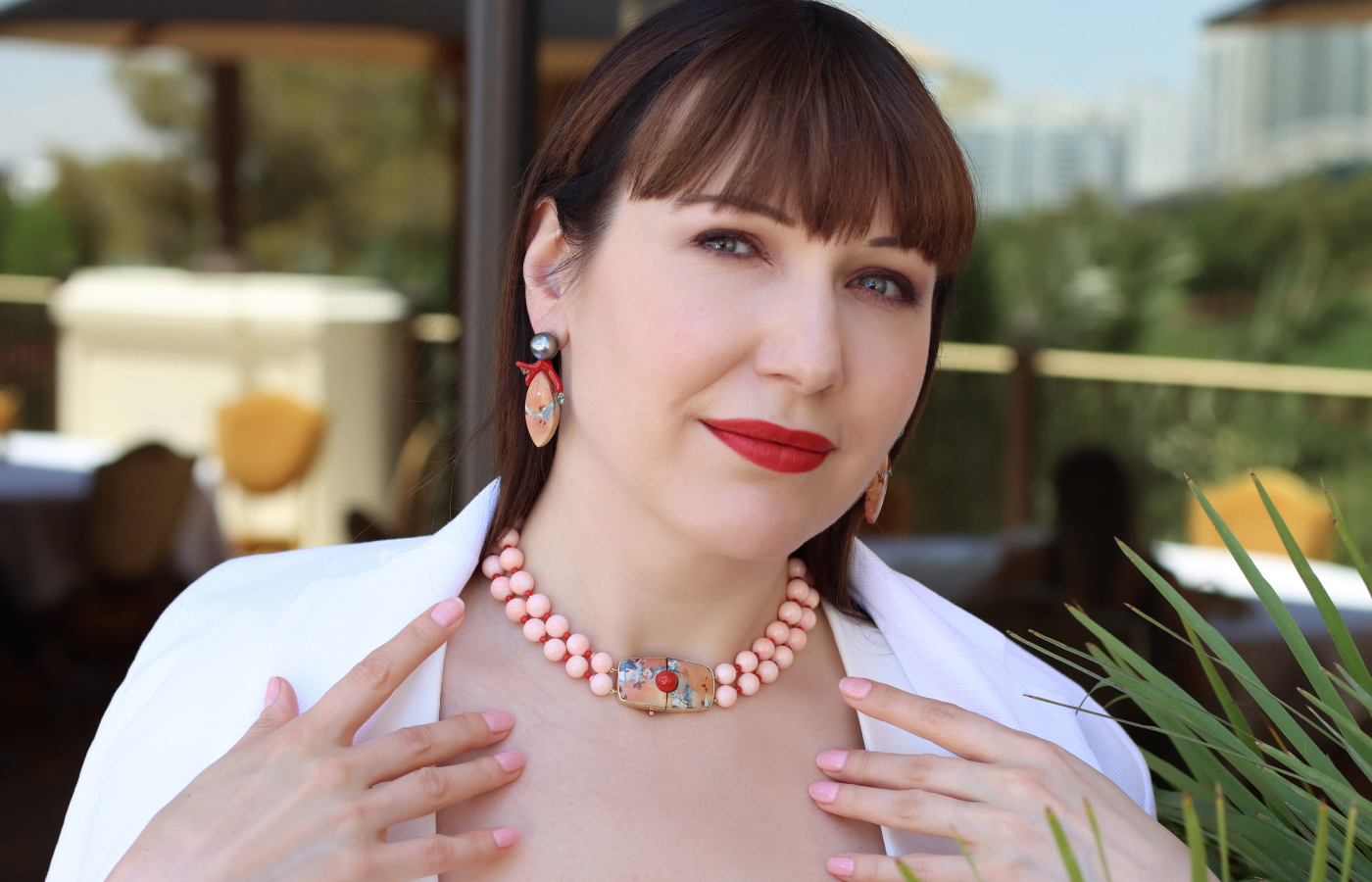 Katerina Perez wears an Assael necklace with 52 Angel Skin coral beads, 50 Sardinian coral beads and 61.04 carats of jasper, set in 18k yellow gold, alongside a pair of earrings with Tahitian pearls, Maligano jasper, coral and grey blue spinels, also set in 18k yellow gold 