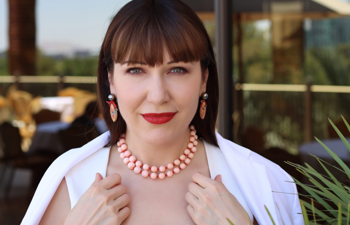 Katerina Perez wears an Assael necklace with 52 Angel Skin coral beads, 50 Sardinian coral beads and 61.04 carats of jasper, set in 18k yellow gold, alongside a pair of earrings with Tahitian pearls, Maligano jasper, coral and grey blue spinels, also set in 18k yellow gold 