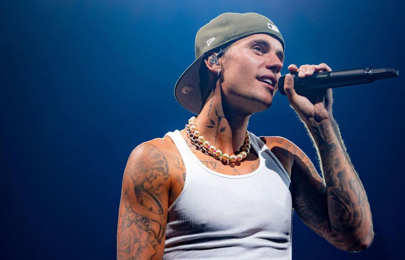 Singer Justin Bieber wearing a strand of pearls during a concert