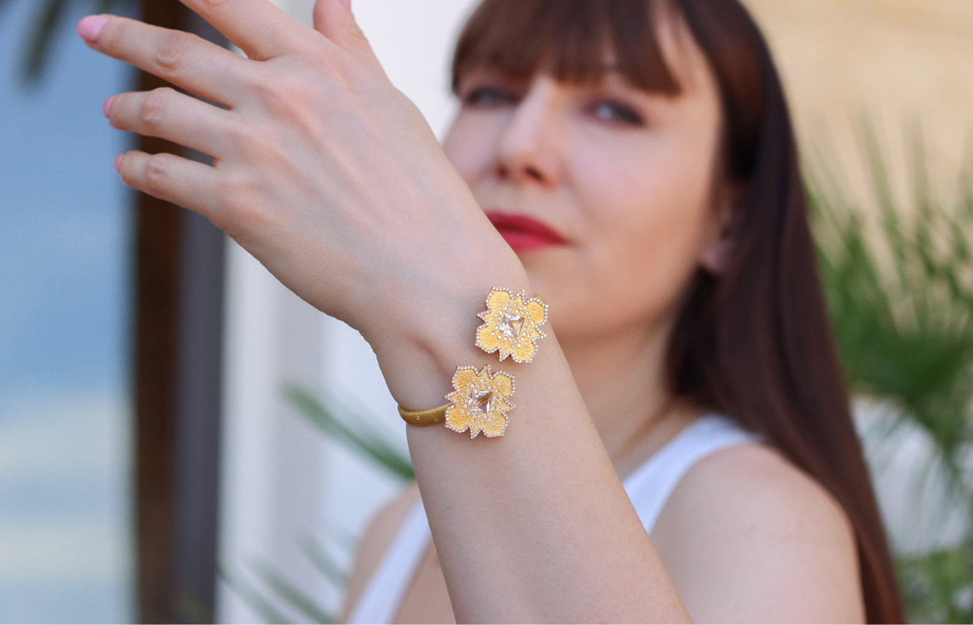  Katerina Perez wears the COOMI Trinetra cuff bracelet with 1.73 carats of diamonds and 4.58 carats of rock crystal, set in 20k yellow gold 