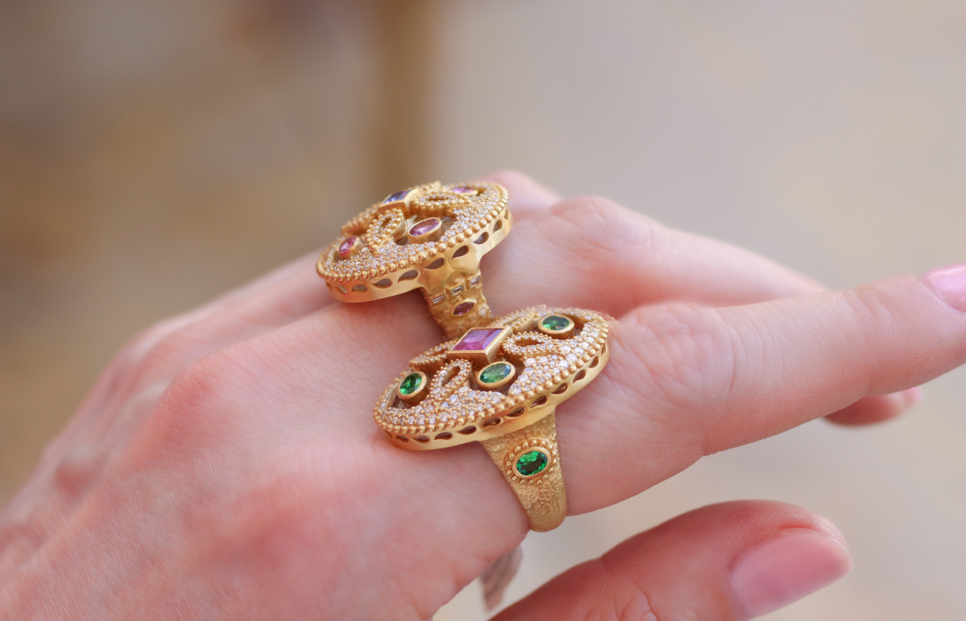  The details on the side profile of two rings from the COOMI Trinetra collection, both in 20k yellow gold, and set with diamonds, rock crystal, tsavorites, pink tourmalines and tanzanites 