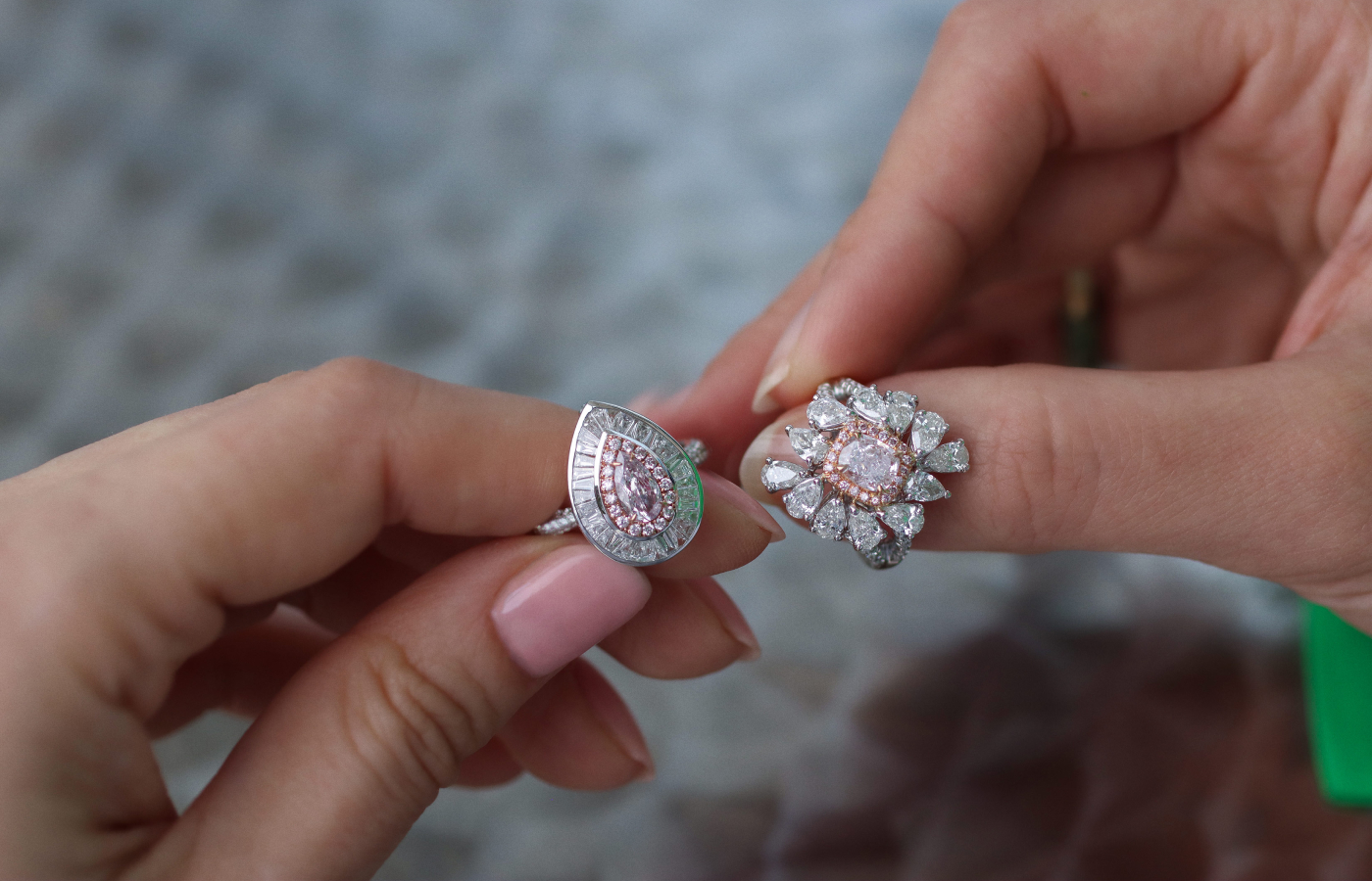  Katerina Perez holds a ring with a pear-shaped 0.35 carat fancy pink diamond (left) with tapered and round diamonds and a second ring with a 1.01 carat, SI2 clarity light pink diamond, surrounded by 12 pear-shaped diamonds of 1.93 carats and further pink and colourless diamonds, both in 18k white gold