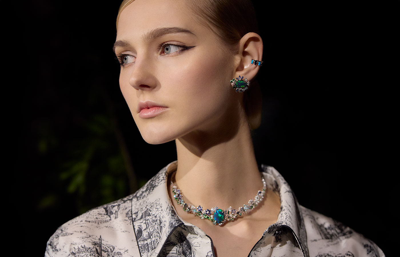 A model wears pieces from the Diorama & Diorigami High Jewellery collection, including a necklace and earrings with black opals, diamonds, sapphires, Paraiba-type tourmalines and tsavorite garnets in white gold 