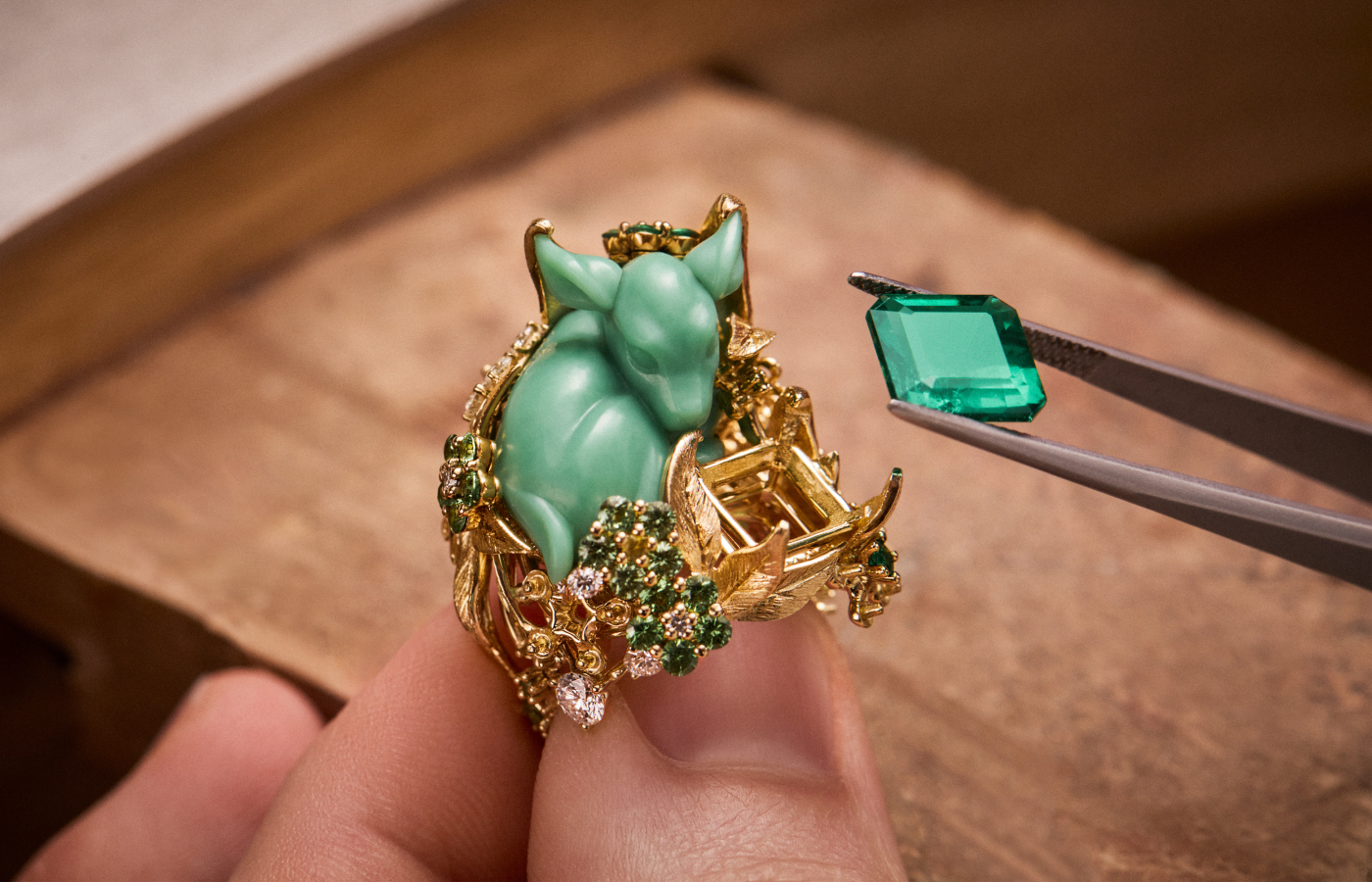  Diorama Foret Enchantée ring with a ‘sleeping’ glyptic chrysoprase fawn, a large Colombian emerald and further emeralds, diamonds and tsavorite garnets, set in engraved 18k yellow gold 