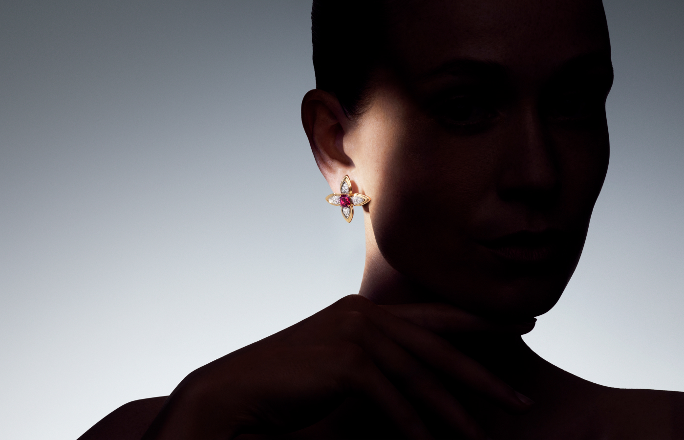 Model wearing Louis Vuitton Splendeur earrings with 2.99 - carats of cushion step-cut rubies and diamonds in gold and platinum from the Awakened Hands, Awakened Minds collections
