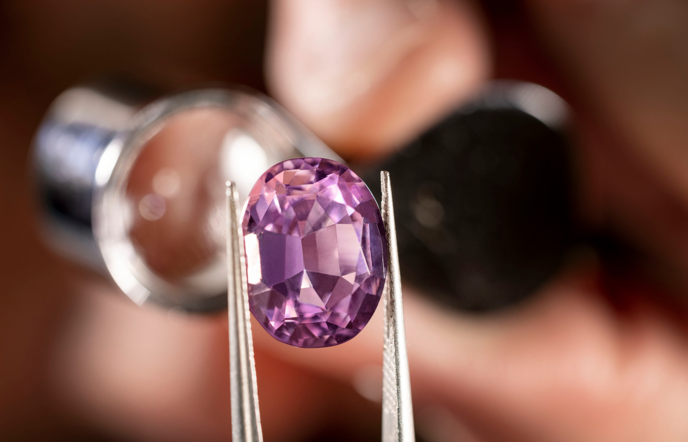Bvlgari artisan inspecting an oval-cut amethyst before setting onto the Earth Song necklace from the  Aeterna collection