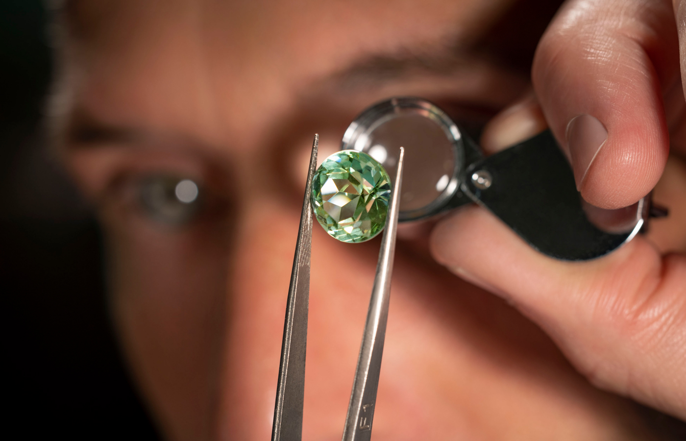  Bvlgari artisan inspecting a green tourmaline before setting onto then Earth Song necklace from the Aeterna collection