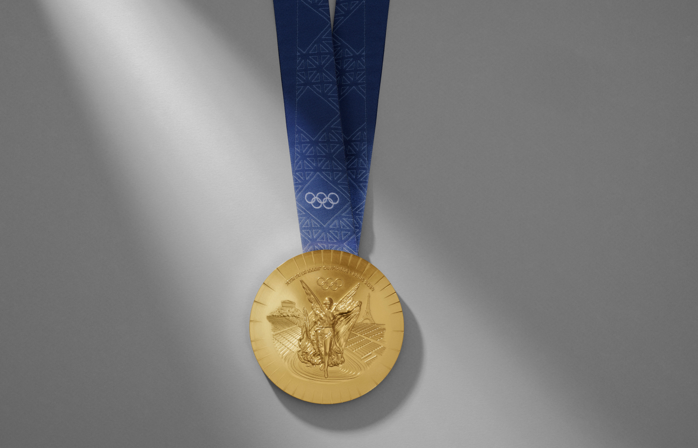  One side of the Paris 2024 Olympics medals, with a traditional image of the Greek goddess of victory Nike in front of Athens and the Eiffel Tower