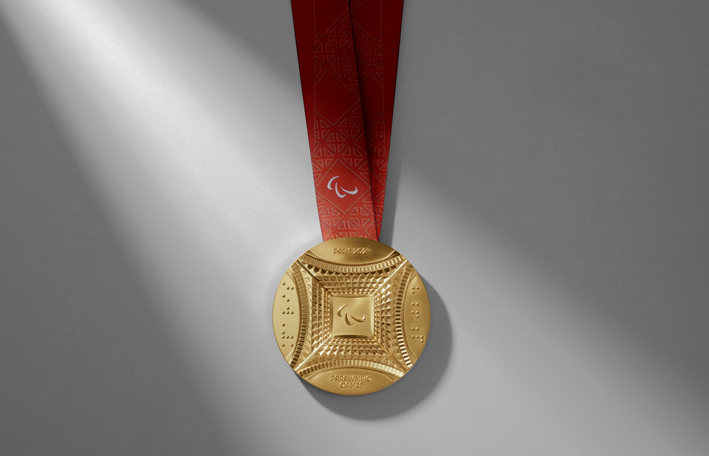  The gold medal for the Paris 2024 Paralympic Games, with Braille inscriptions and a view of the Eiffel Tower as seen from below