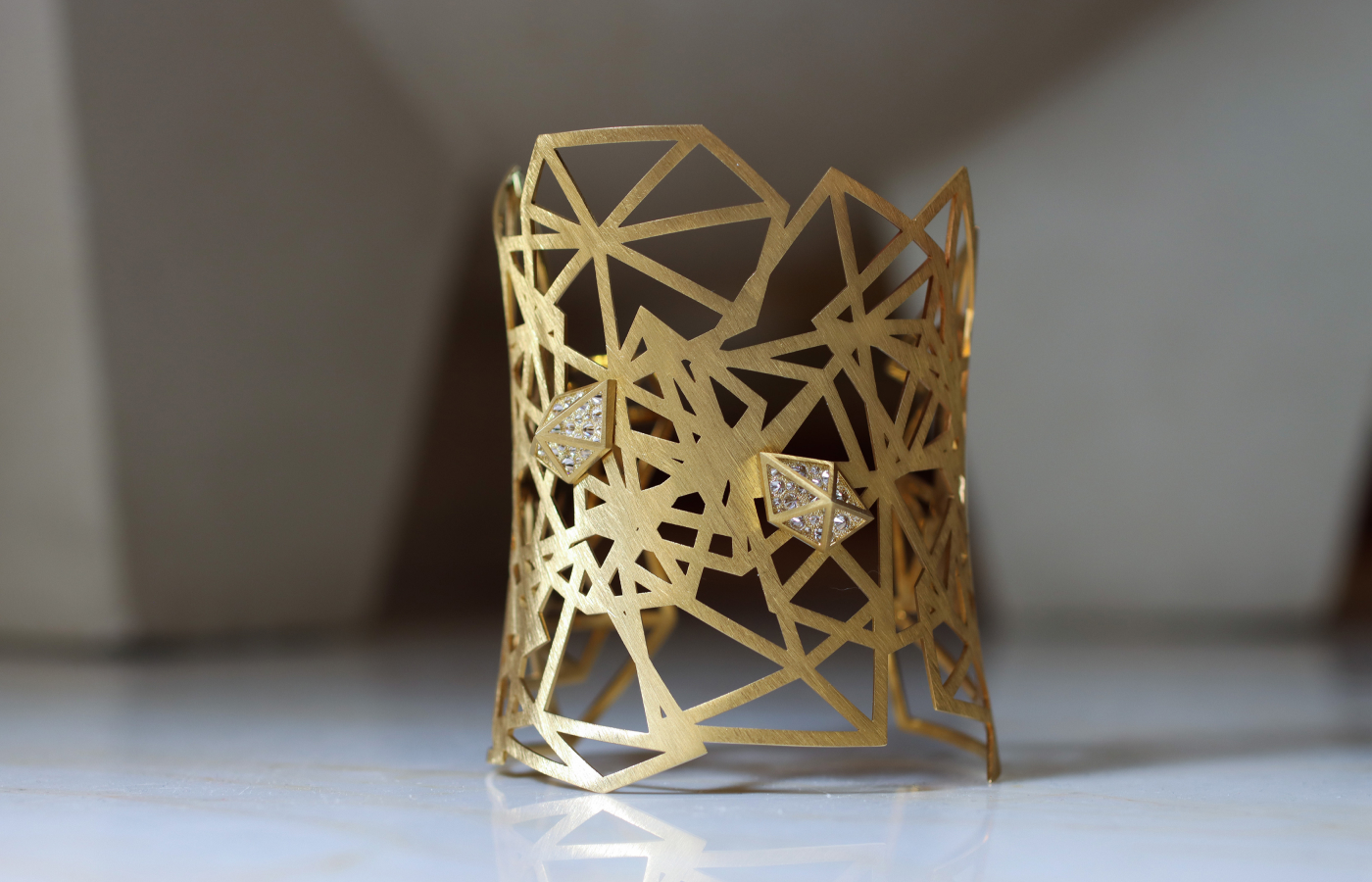  Robert Guild Shattered cuff bracelet crafted in brushed 18k yellow gold with 50 reverse-set round brilliant-cut diamonds totalling 1.20 carats 