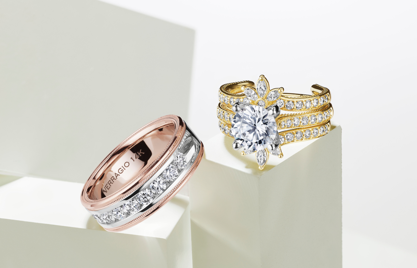  Vanguard Embellisher™️ from the Verragio Vanguard collection with an oval-shaped diamond engagement ring, both in 14k yellow gold, alongside a men’s band with diamonds in 18k rose gold 