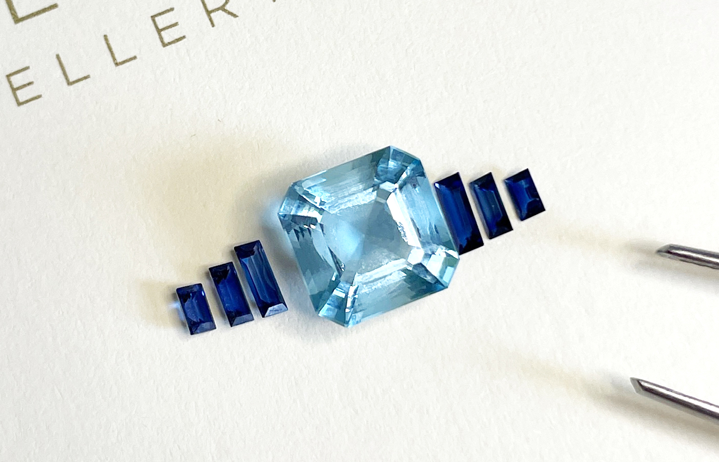 A custom-cut octagonal aquamarine paired with blue sapphire baguettes, designed as part of Hattie Rickards' bespoke engagement ring for Portia