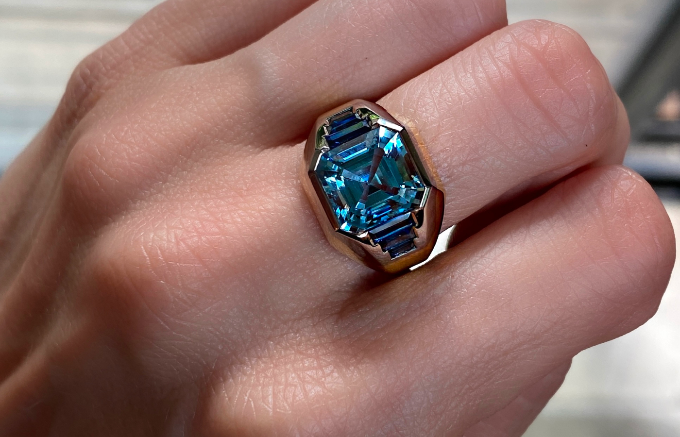  A bespoke engagement ring created by Hattie Rickards for her client Portia with a custom-cut octagonal aquamarine and blue sapphire baguettes, set in yellow and white gold
