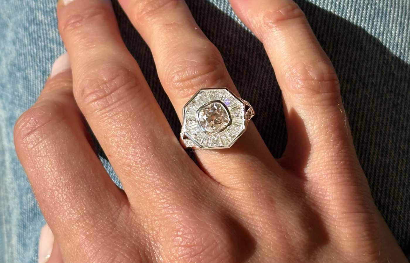  A closer look at Hattie Rickards’ bespoke Halo ring being worn, crafted with a brilliant-cut heirloom diamond along with custom-cut tapered baguettes and carré-cut diamonds, set in white platinum