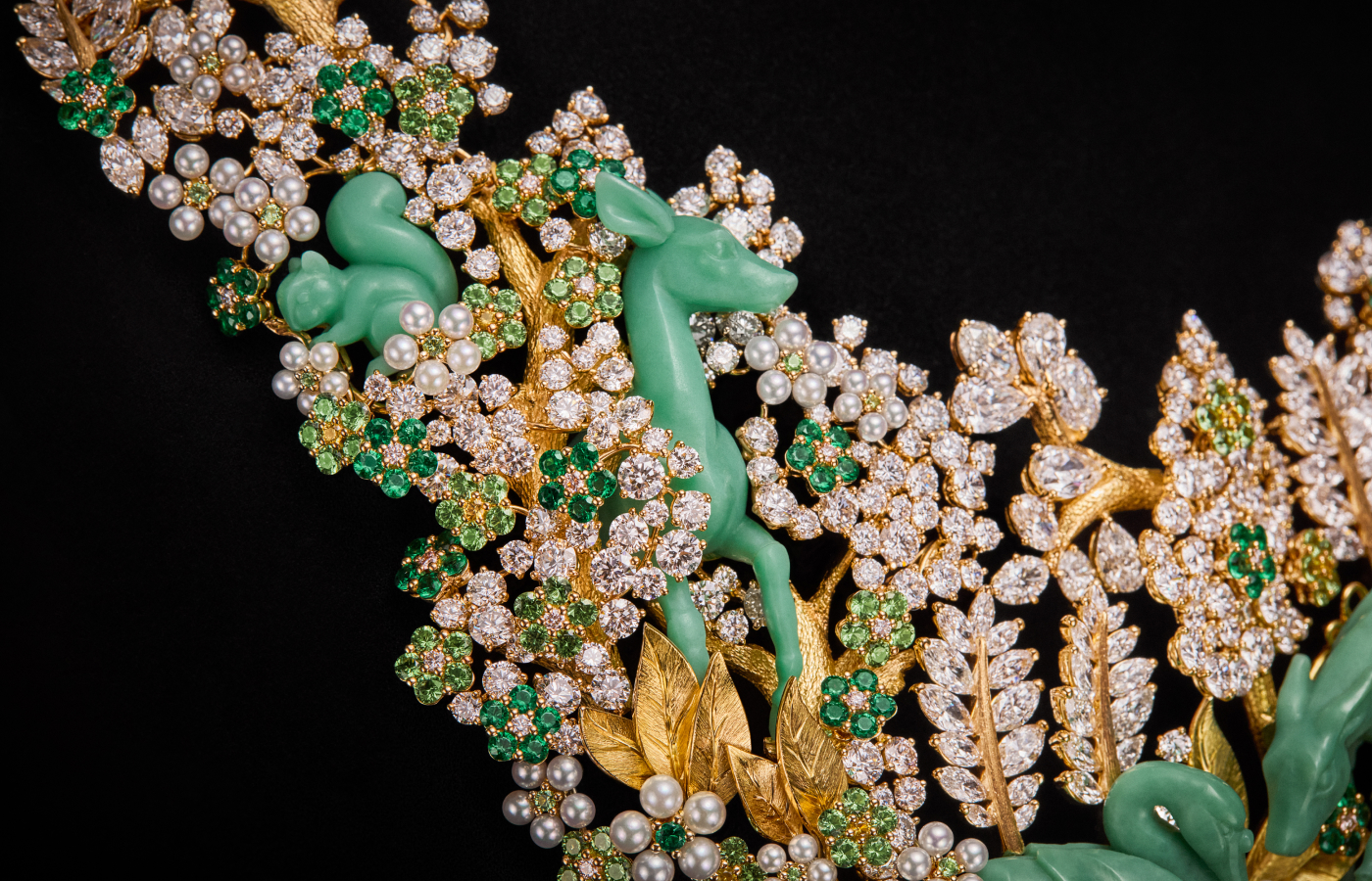  A closer look at the three-dimensional chrysoprase deer and squirrel in the Diorama Forêt Enchantée necklace, part of the Diorama & Diorigami High Jewellery collection, surrounded by diamonds, emeralds, tsavorite garnets, and pearls, set in engraved 18k yellow gold