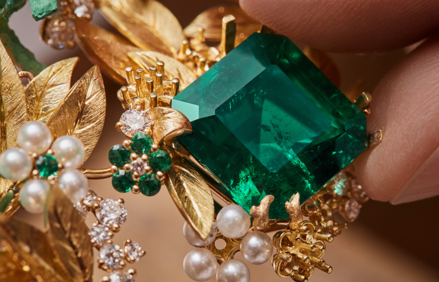 Adding a 16.16-carat Colombian emerald to the Diorama Forêt Enchantée necklace, surrounded by diamonds, smaller emeralds, and pearls, set in 18k yellow gold, part of the Diorama & Diorigami High Jewellery Collection