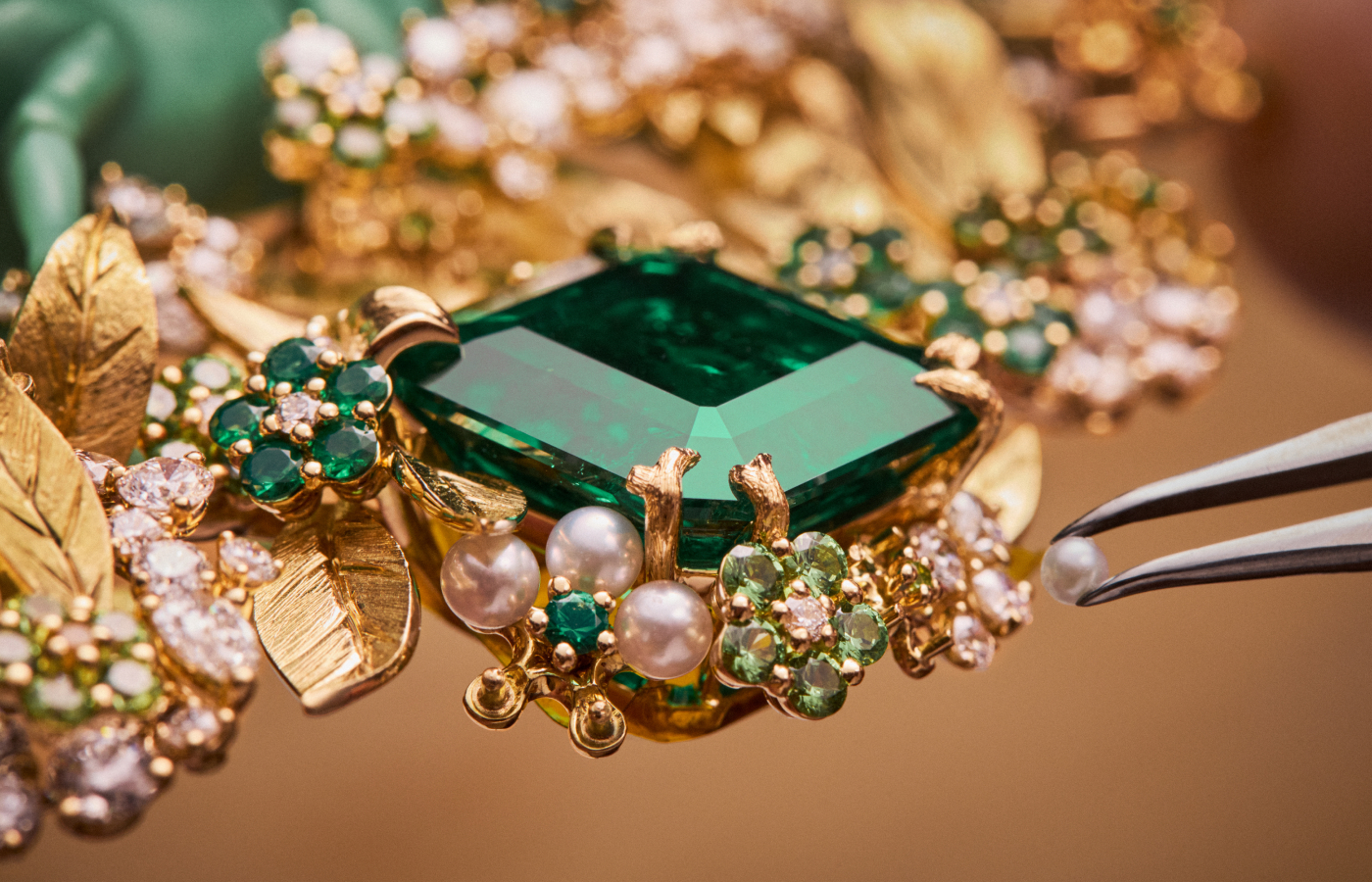  Adding a pearl to the to the Diorama Forêt Enchantée Necklace, surrounded by a large emerald, diamonds, smaller emeralds, and pearls, set in 18k yellow gold, part of the Diorama & Diorigami High Jewellery Collection