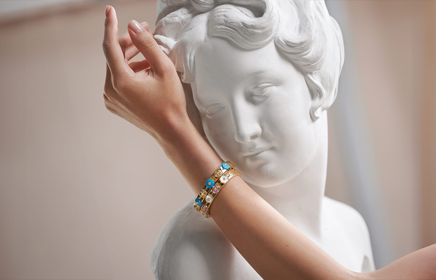 Miseno bangles from the Baia collection, including one with turquoise, 1.23 carats of yellow sapphires and 0.61 carats of white diamonds, alongside a second with mother of pearl, 1.32 carats of pink sapphires and 0.60 carats of white diamonds 