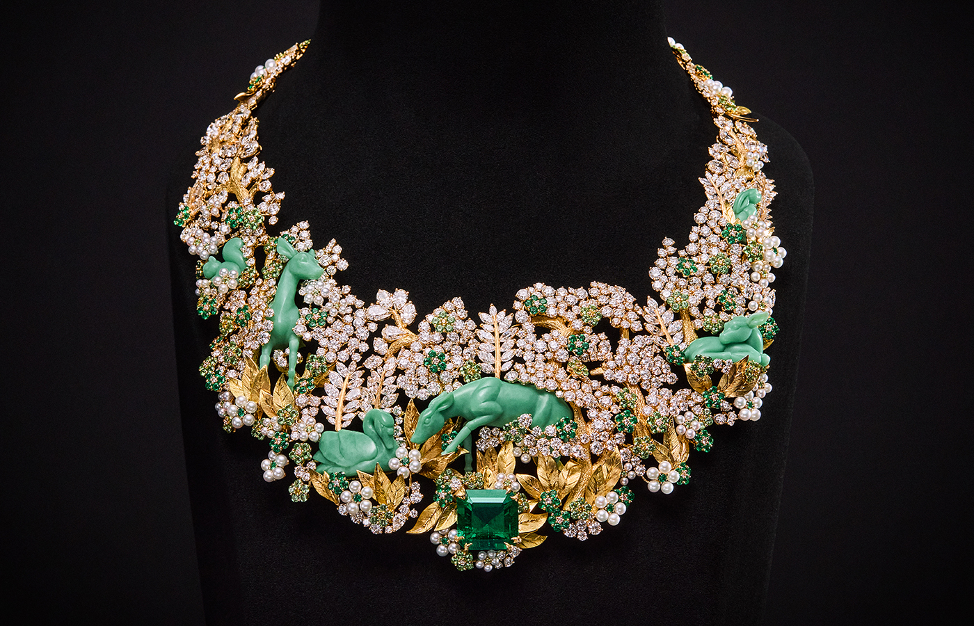 Diorama Forêt Enchantée necklace from the Diorama & Diorigami High Jewellery Collection, set with a 16.16 carat Colombian emerald, smaller emeralds, tsavorite garnets, pearls, and brilliant-cut diamonds, featuring sculpted chrysoprase animals crafted using the technique of glyptic arts, set in 18k yellow gold