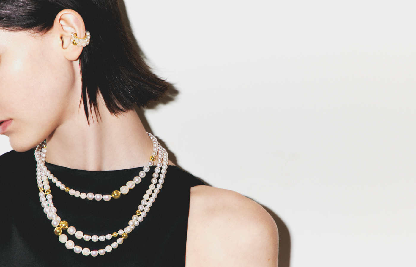 Model wears a M/G Tasaki Sliced Sphere necklace with Freshwater pearls in 18k yellow gold