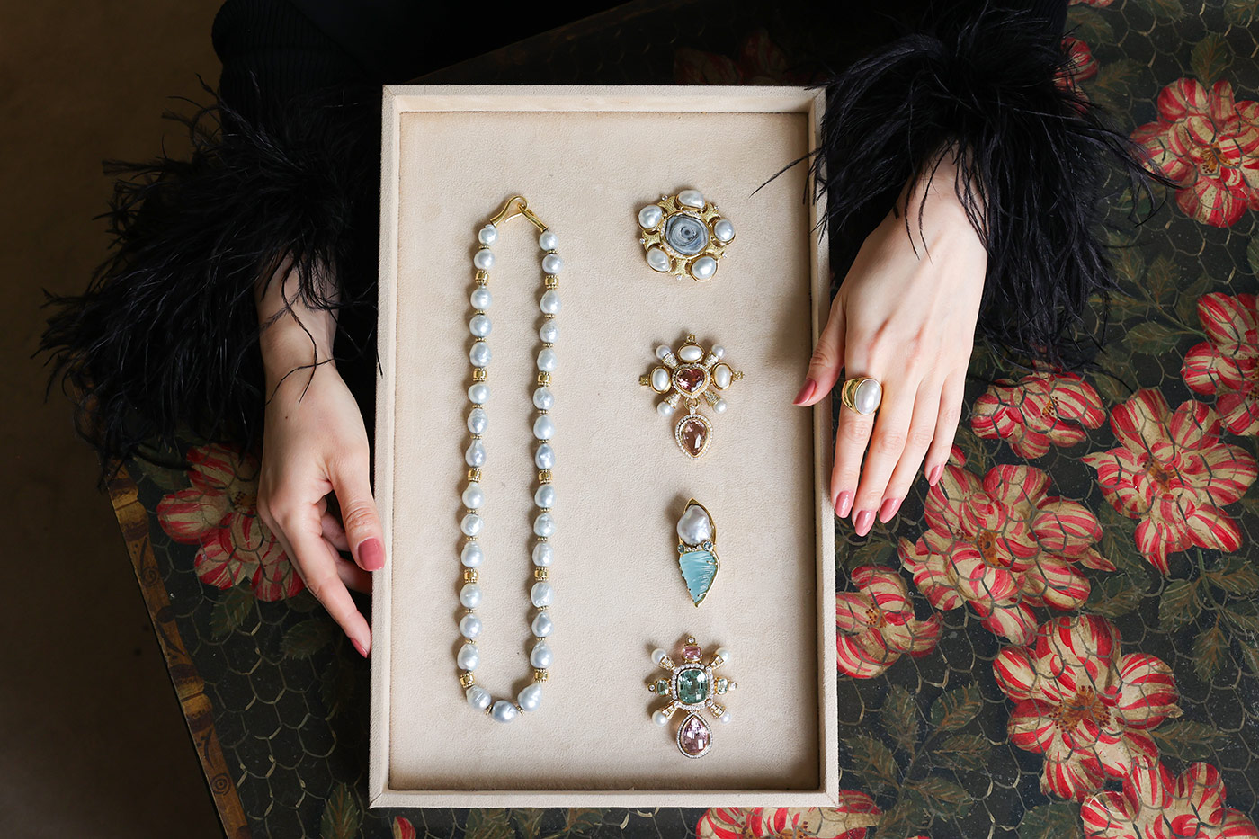 A selection of jewels by Elizabeth Gage, including a necklace with 31 cultured South Sea pearls, a pin with a chalcedony rose, five South Sea baroque pearls, and brilliant-cut diamonds (top right), and a pin with a 32.97 aquamarine carving and a baroque South Sea pearl (third from top)