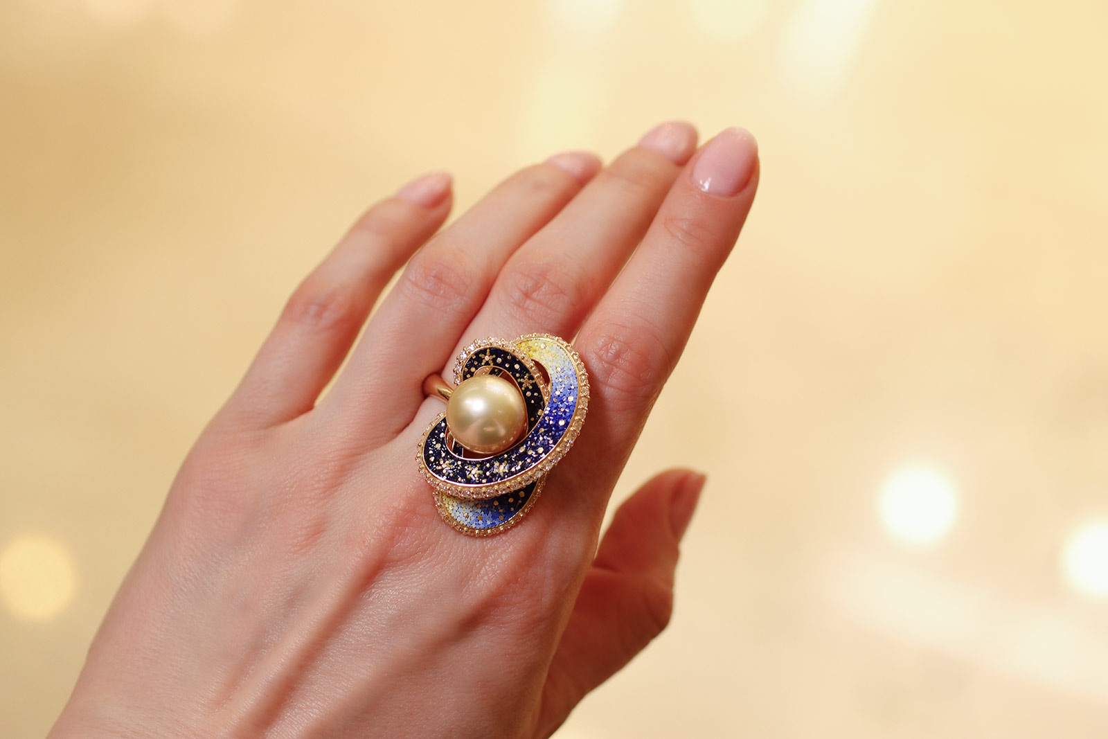  Wearing the Sicis Saturno ring with three-dimensional rings of micromosaics, edged in white diamonds, surrounding a large Australian South Sea pearl in 18k yellow gold 