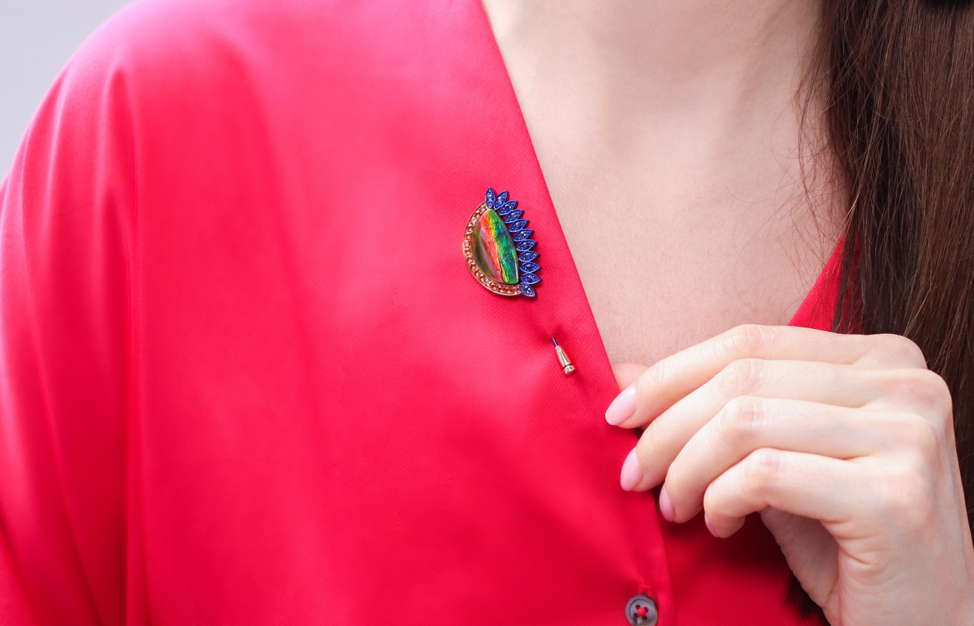  Wearing the Susana Grau Batlle Evolution through Time ‘Time 1’ pin with a 12.34 carat ammolite, 16 round-cut orange sapphires, and 11 round-cut blue sapphires set in titanium and 18k yellow gold, part of the A Trilogy of Evolution High Jewellery collection