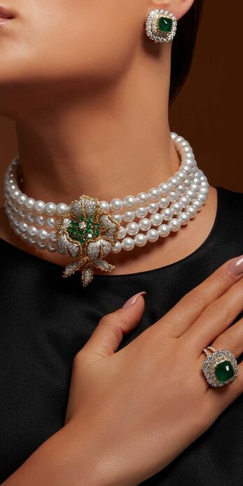 Pearl choker with a central floral motif in diamonds and emeralds, set in 18k yellow gold 
